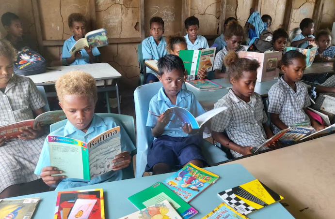 Donated Tasmanian schoolbooks travel by barge, carried by hand on jungle tracks to reach PNG children